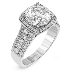 This eye-catching modern white gold ring is accentuated by an elegant halo highlighted with .64 ctw of round cut white diamonds.