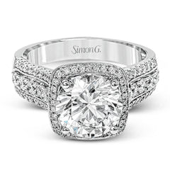 This eye-catching modern white gold ring is accentuated by an elegant halo highlighted with .64 ctw of round cut white diamonds.