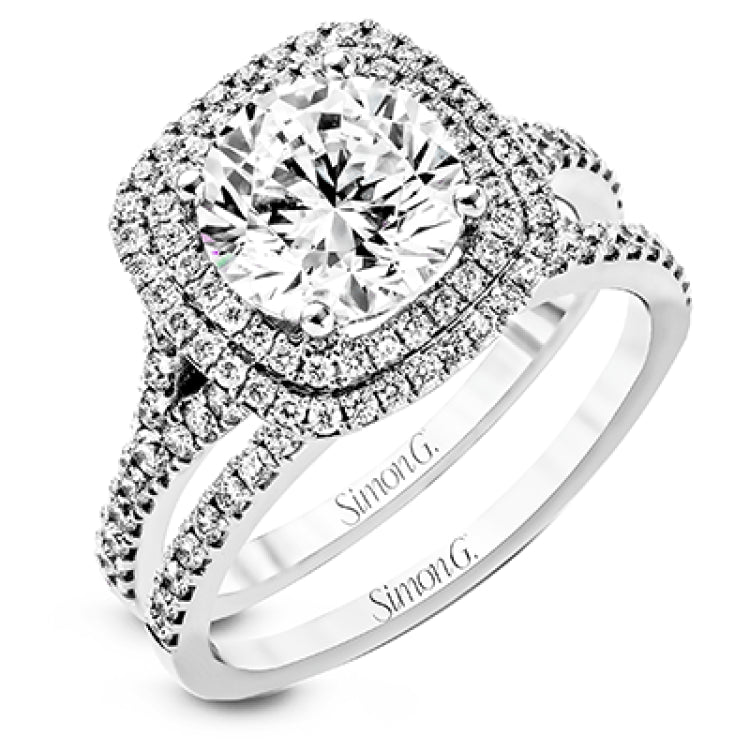 This remarkable white gold engagement ring and wedding band set features a contemporary setting with an eye-catching halo highlighted by .67 ctw of round cut white diamonds.