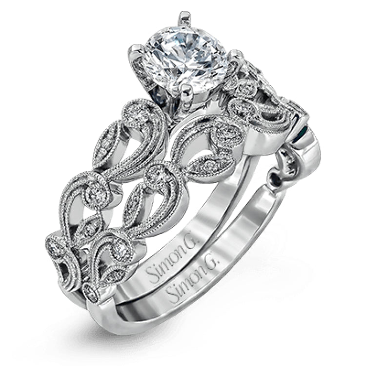 This delicate floral inspired white gold engagement ring and wedding band set is accentuated with .28 ctw shimmering round cut white diamonds.