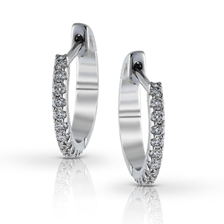 Featuring a classic hoop style with modern accents, these sparkling white gold earrings are accentuated by .17 ctw of round cut white diamonds.