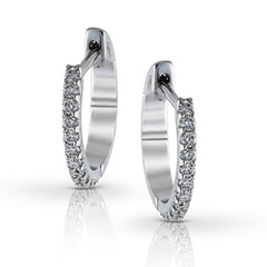 Featuring a classic hoop style with modern accents, these sparkling white gold earrings are accentuated by .17 ctw of round cut white diamonds.