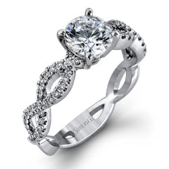 The intricate twisted design of this modern white gold engagement ring and wedding band set is set with .65 ctw of striking round cut white diamonds.