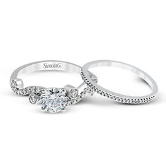 Playful and modern, this white gold wedding set sparkles with .31 ctw of round white diamonds highlighting the center stone.