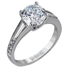 Contemporary in its design, this white gold engagement ring features .17 ctw of round cut white diamonds highlighted by .50 ctw of tapered baguette cut side diamonds.