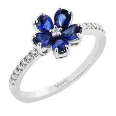 This delicate right hand ring has a flower design with petals of pear-shaped sapphires 1.06 ctw., with a diamond center and shank 0.13 ctw.