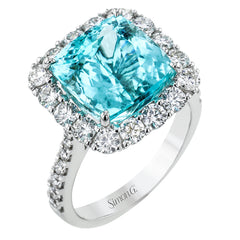 This stunning right-hand ring features a cushion cut 6.02 ct. paraiba tourmaline, surrounded by a halo of white diamonds with diamonds half way down the sides 1.47 ctw.