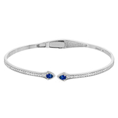 This modern hinged bangle adds a touch of color with two precious gemstone accent, set off by .30 ctw of white diamonds along the sides.