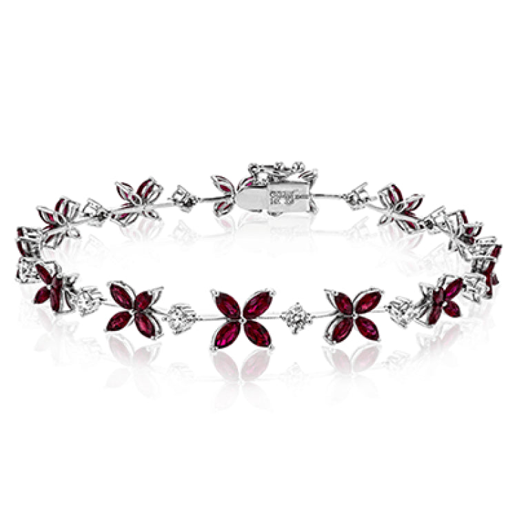 This bracelet charms with a floral design set with 3.58 ctw of rubies and .96 ctw of white diamonds.