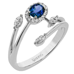 This delightful 18k gold ring is set with one .30 ctw sapphire and .06ctw of white round diamonds and .16ctw marquise diamonds in its bypass design
