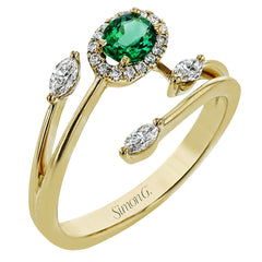This delightful 18k white and yellow gold ring is set with one .25 ctw emerald and .06ctw of white diamonds and .16ctw marquise diamonds in its bypass design