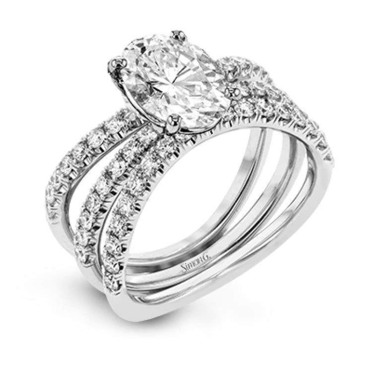 This distinctive bridal set design features a double-layer wedding band that fits around the engagement ring. The set contains .77 ctw of white diamonds.