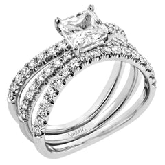 This distinctive bridal set design features a double-layer wedding band that fits around the engagement ring. The set contains .77 ctw of white diamonds.
